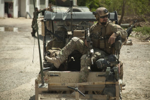 Ein Angehöriger der Koalitionsstreitkräfte sichert vom Fahrzeug aus bei einer Patrouille mit den afghanischen Spezialeinsatzkräften, die am 14. April 2013 einen afghanischen Gouverneur in der Provinz Helmand eskortieren. Bild: DoD photo by Sgt. Pete Thibodeau, U.S. Marine Corps/Released. Bildlizenz